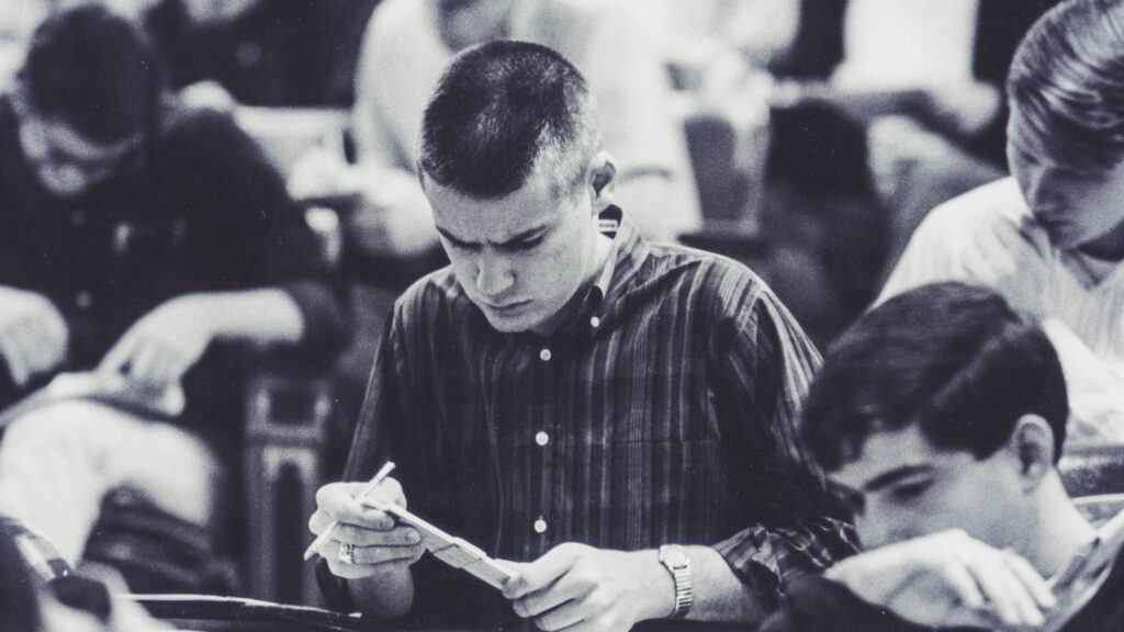 A male student uses a slide rule in class