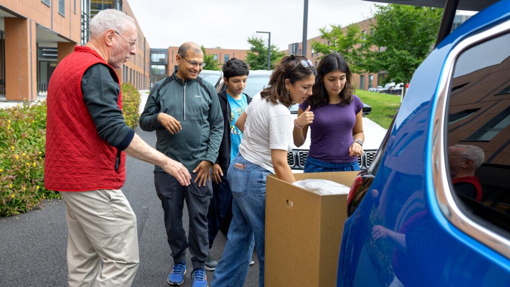 President Mike Kotlikoff with a family loading items into a bin from a car