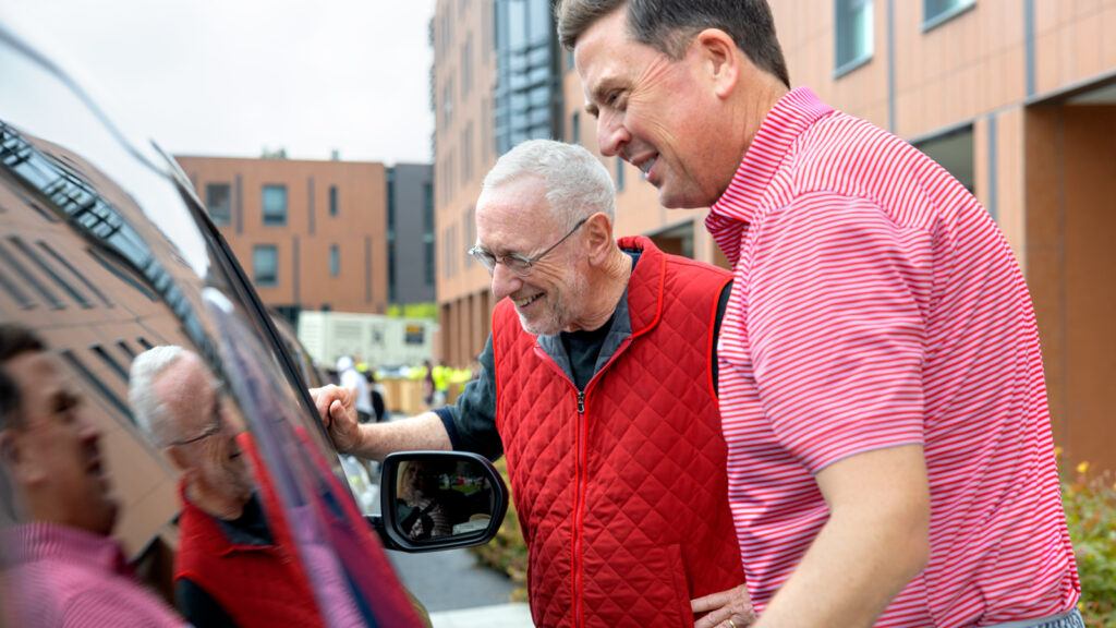 President Mike Kotlikoff and SCL VP Ryan Lombardi smiling at the occupants of a car