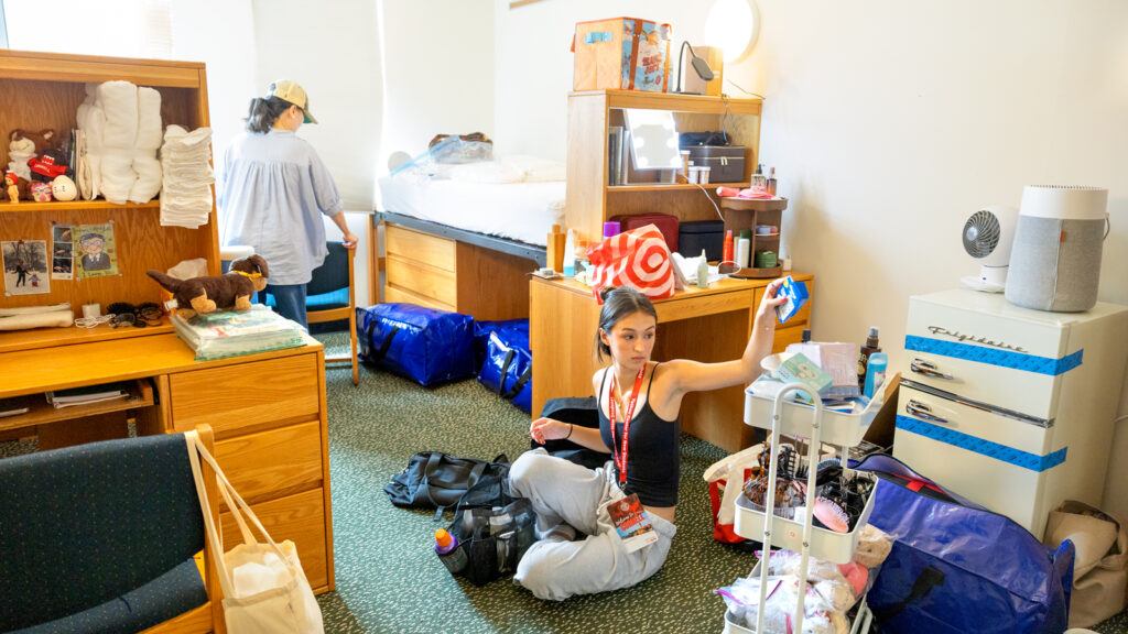 A new student and her mom unpack belongings in her dormroom