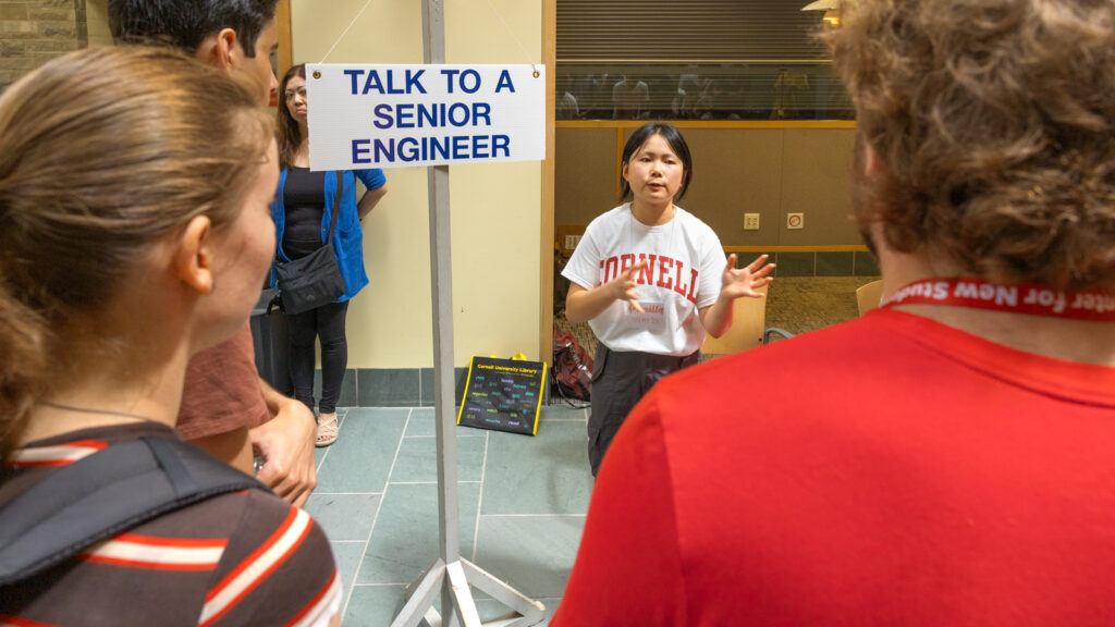 a student chats with others next to a sign that says "talk to a senior engineer" during Move-In events on campus, August 2026