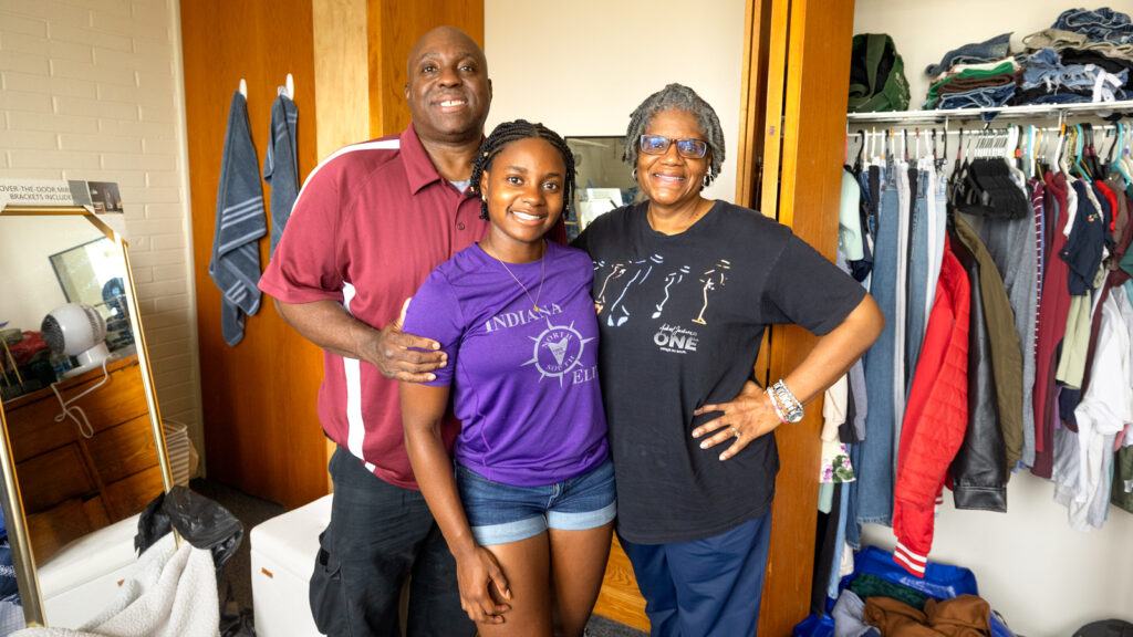 a student and family members pose for a photo in a residence hall room during Move-In, August 2026