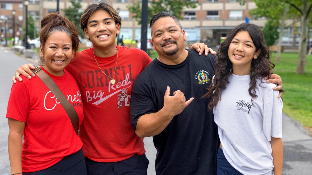 Four family members pose for a photo on North Campus during Move-In, August 2026