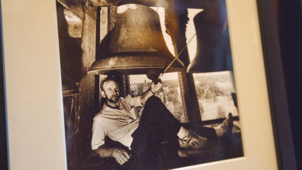 a framed, undated black-and-white photo in the Chimes Museum shows then-Chimes advisor Robert Feldman ’66, PhD ’75, sitting beneath one of the bells in the McGraw Tower belfry