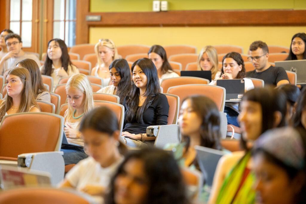 Rows of students sit in a classroom with their laptops in front of them in the Plant Sciences building
