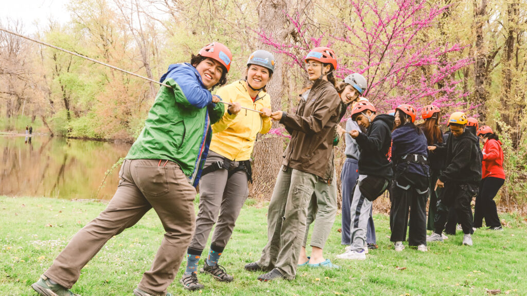 Instructors and students pull on a rope to tighten the line during a PE class at Stewart Park.