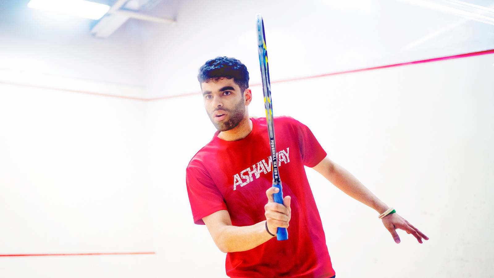 Veer Chotrani swings his racquet while playing squash.
