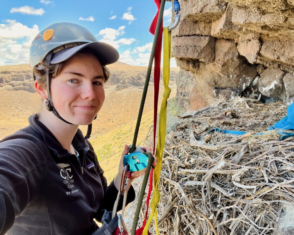 Emma Regnier smiles for a selfie next to a nest while climbing.