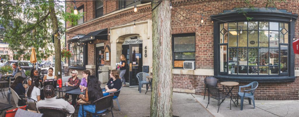 exterior view of the Sheldon Court patio and entrance with patrons at tables in 2026