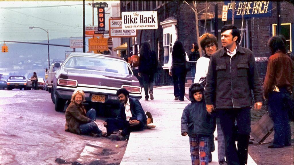 pedestrians stroll College Avenue near Sheldon Court in the early 1970s, with stores like The Bike Rack and Hill Drug, visible along the street