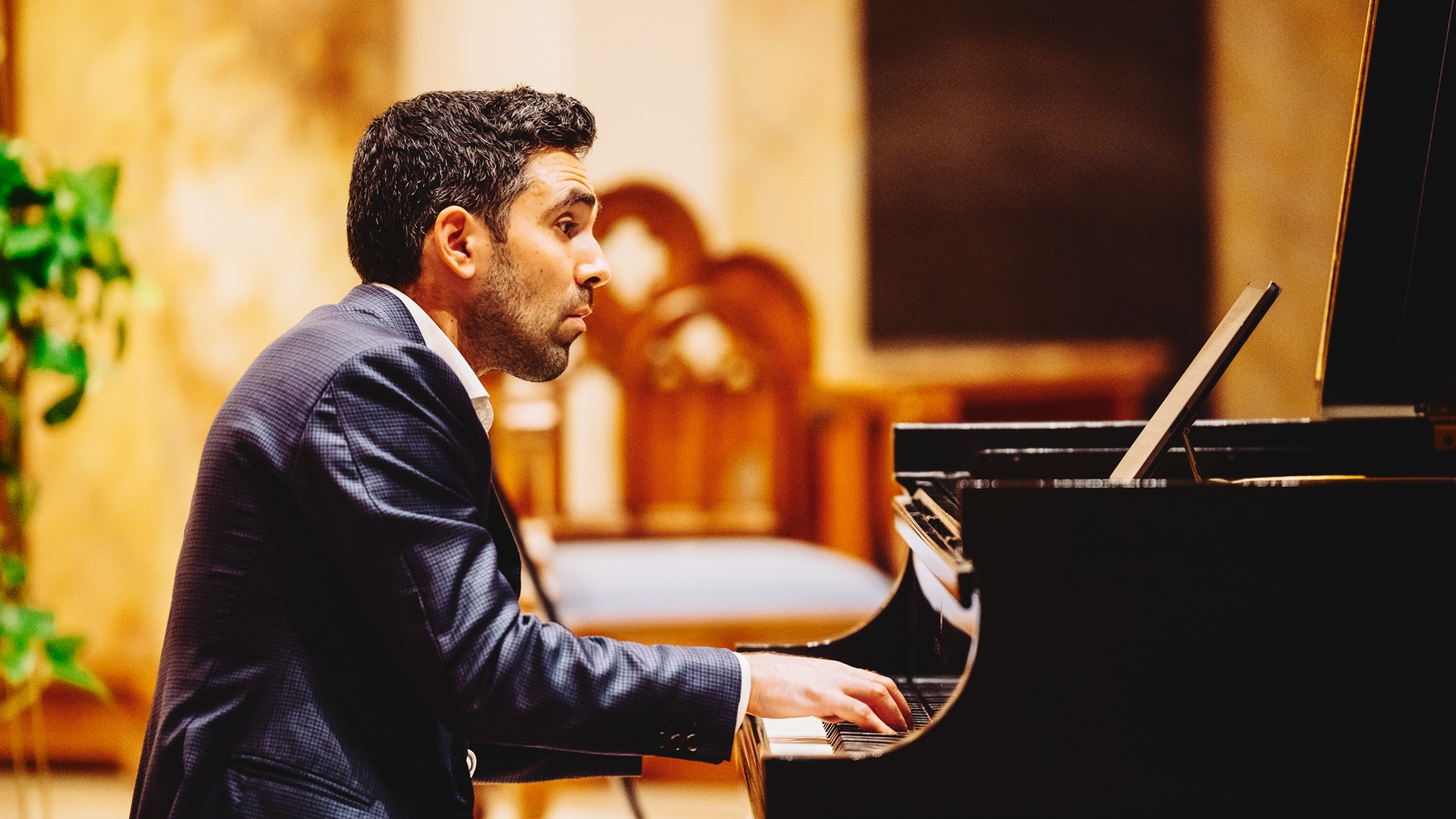 Daniel Anastasio playing piano in a suit.
