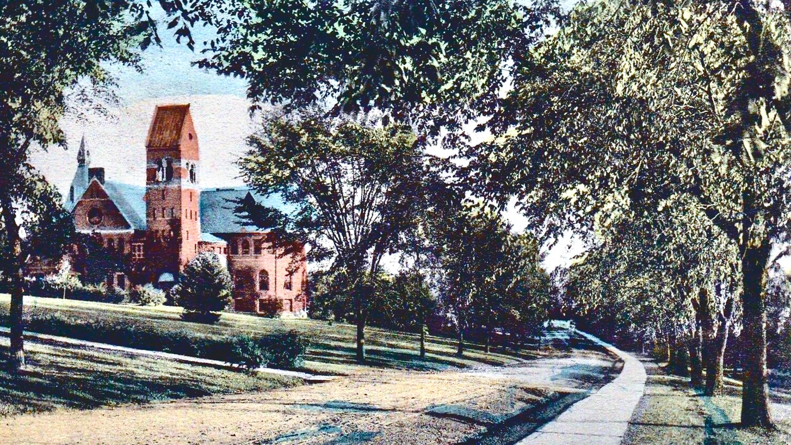 a colorized postcard from 1907 shows a view of Central Avenue looking south as it curves past Barnes Hall on campus with then-young elm trees lining both sides of the street