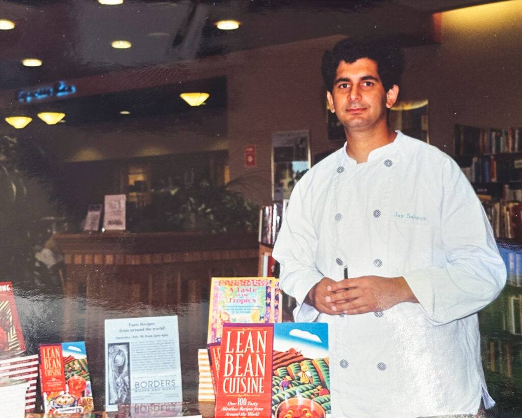 Jay Solomon in chef's whites with his cookbooks in a Borders book store