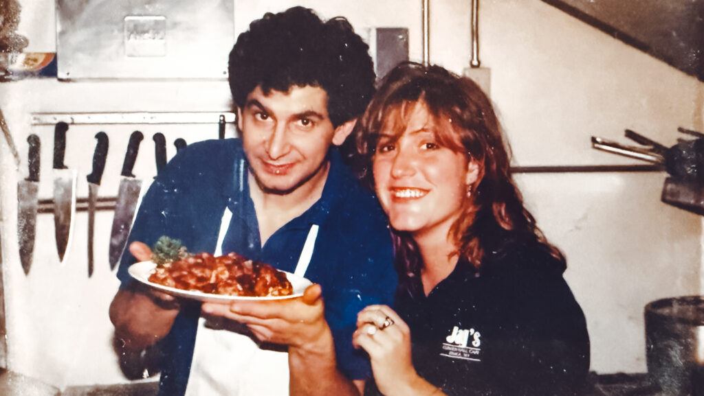 Jay Solomon with a woman at his cafe in Ithaca. He is holding a plate of food.