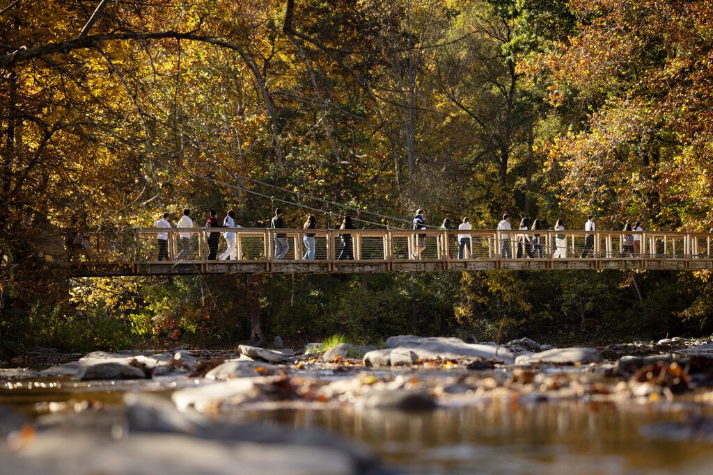 Students walk across the bridge over Flat Rock at Six Mile Creek.
