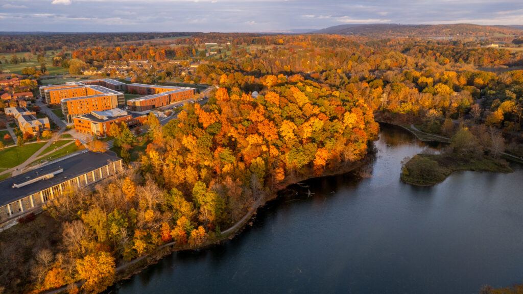 A view from above of the fall foliage in shades of reds, oranges, yellows, and greens on North Campus and along Beebe Lake.