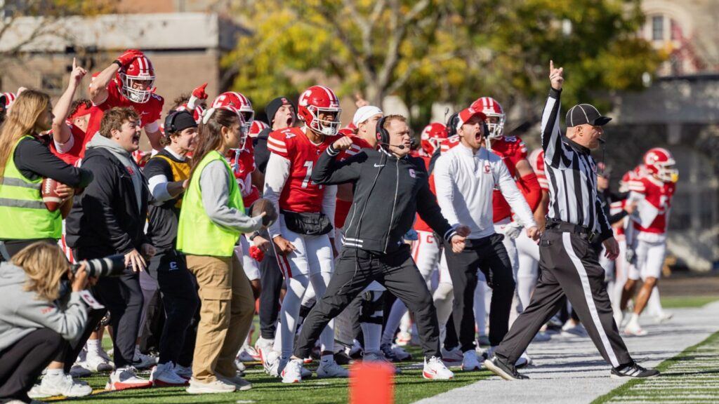 Cornell coaches and players celebrate on the sideline.