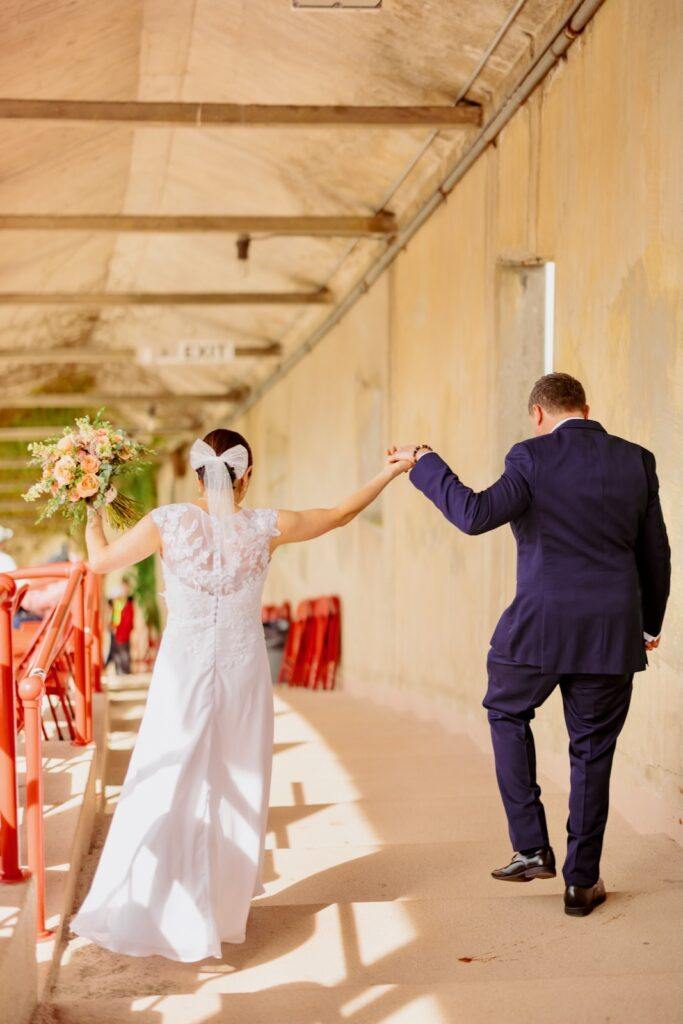Yuko Jingu and Jeffry Clausen Jr. holds hands and walk through the stadium.