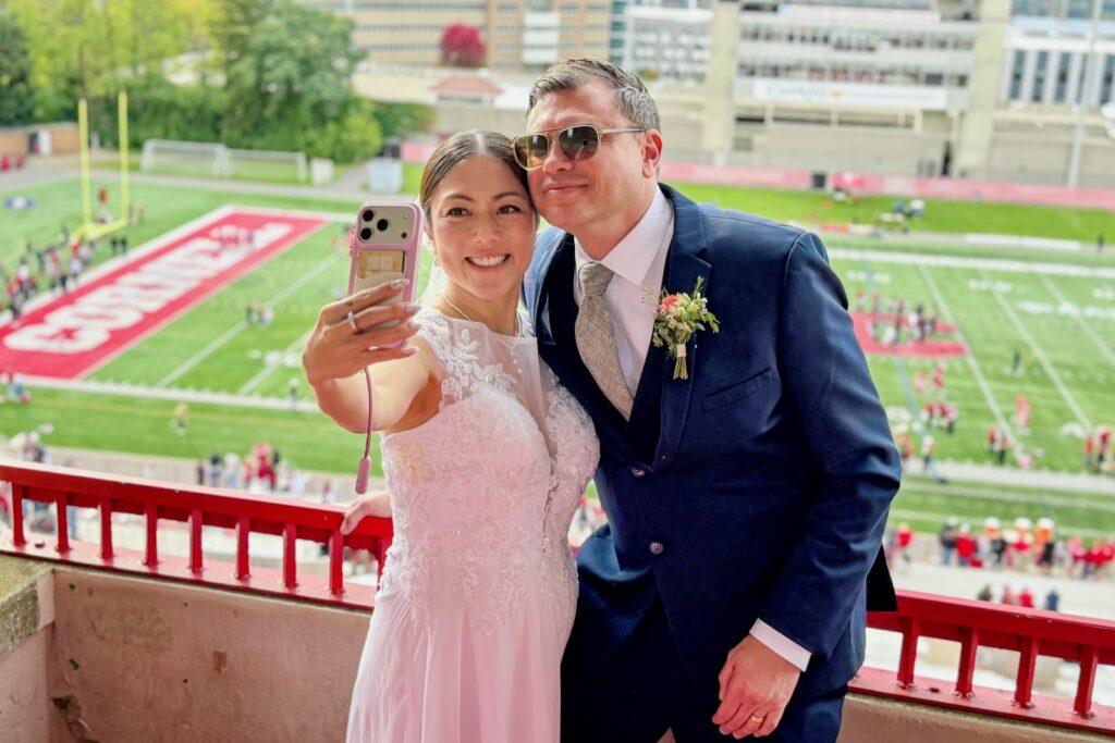 Yuko Jingu and Jeffry Clausen Jr. take a selfie together overlooking the football game. Jeffry Clausen Jr., MS ’26, and Statler staffer Yuko Jingu