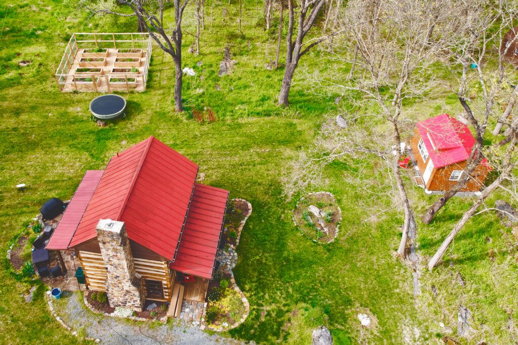 aerial view of the cabin and the surrounding garden, sheds, and grounds