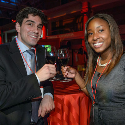 Man and woman smiling and holding wine glasses