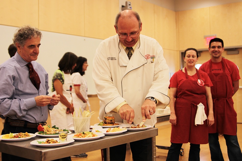 Giuseppe Pezzotti (left) and Robert White, both chef-instructors in the School of Hotel Administration, judge entrées in the "Iron Chef" cooking competition.