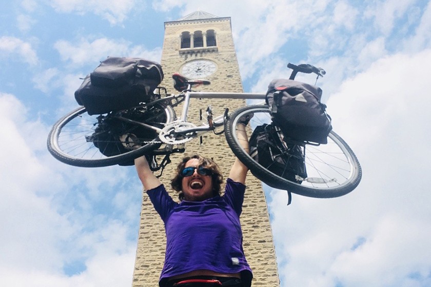 George Epstein '15 hoists his bicycle in front of McGraw Tower.