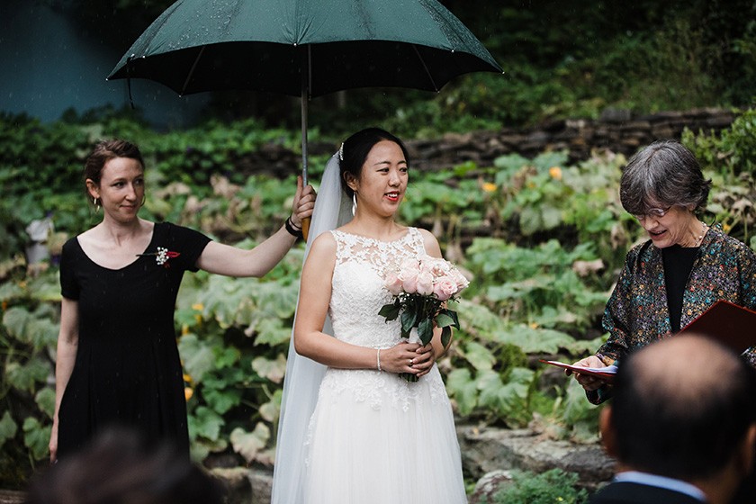 Rachel Conroy holds an umbrella for a wedding client during the ceremony.