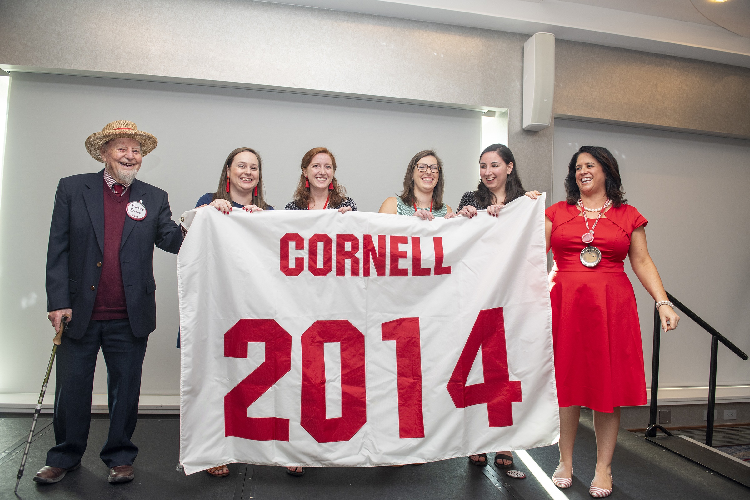 Howard Evans ’44 (left) presents a new Class of 2014 banner to Reunion chairs from the Class of 2014