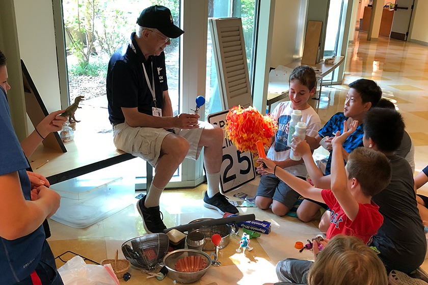 John Galinato sits surrounded by enthusiastic kids