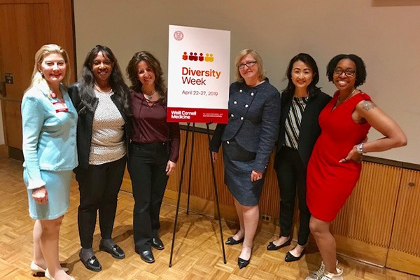 Six women and a sign that reads "Diversity Week"