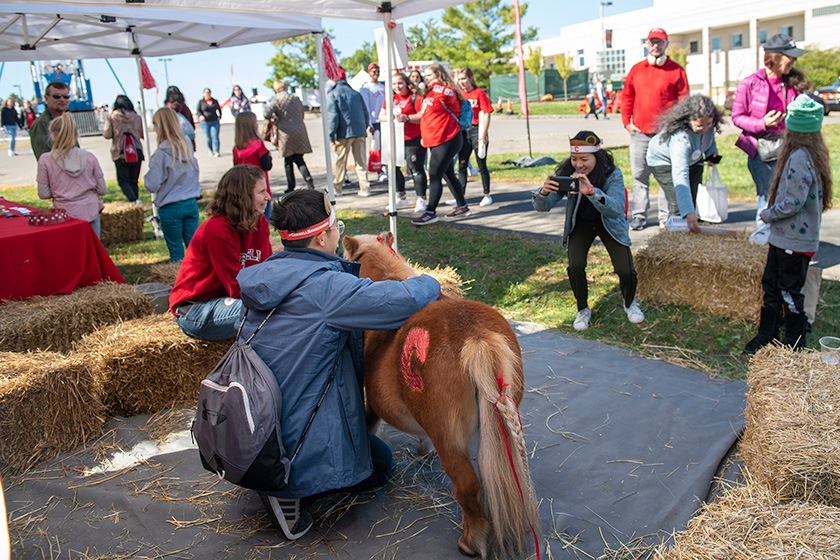 A student poses for a photo with a pony