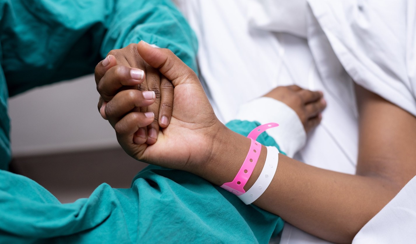 An image of a doctor holding a patients hand.