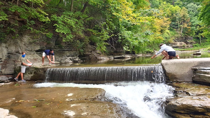 Lou’s students work together to quantify the Fall Creek discharge rate using a measuring tape and a stopwatch.