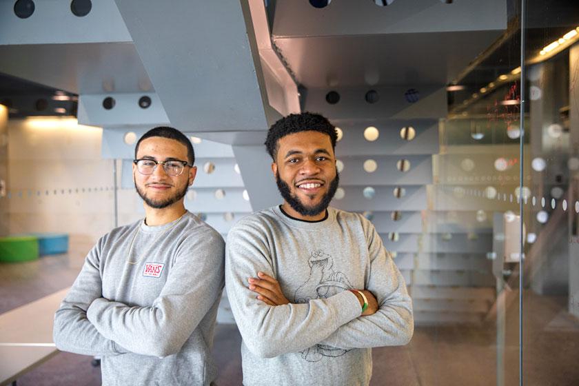 Cornellians standing side by side in Gates Hall