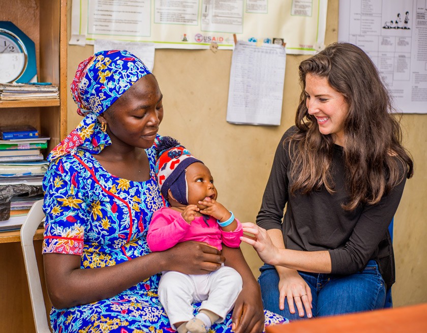Lauren Braun ’11 visiting a government public health clinic outside Abuja, Nigeria to meet a mother whose child has been wearing the Alma Sana bracelet.