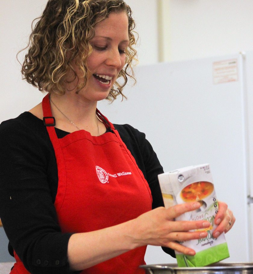 Erin Harner preparing a vegetable soup at a cooking demo before the pandemic.