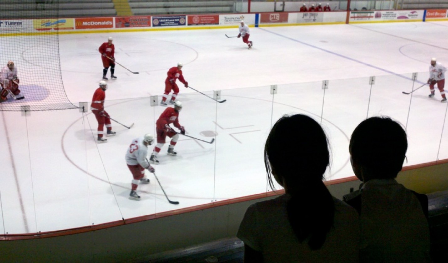 Renata Geer ’82 photographed her children watching a Cornell ice hockey team practice in Lynah Rink.