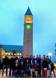 Farid and CUVA members pose in front of the clock tower, lit green in honor of Veteran’s Day 2019.