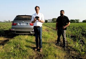 Henry flying a drone in a sugarcane field