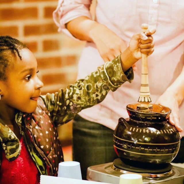 Isela shows a young girl in Brooklyn how to make Mexican hot chocolate