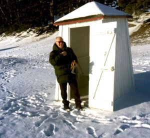 Deiv enters the hut, preparing to plunge into ice-cold water for a swim.