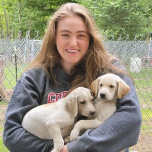 Heather’s student Samantha Sandwick DVM ’24 holding sled dog puppies in summer 2021