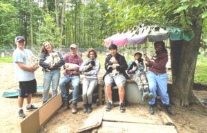 Heather, her son (second from right), and her students visited a sled dog kennel in Michigan in summer 2021. They presented research to dog sledders at the Midwest Sled Dog Educational Expo and collected blood samples from the dogs to identify genes related to different parameters of athletic performance, such as speed, endurance, and heat tolerance.