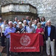 Alumni group photo holding up a Cornell pennant