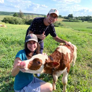 Maryna and her boyfriend Vlad Pinkhasov make friends with a calf in the countryside outside of Kharkiv, Ukraine, in August 2021