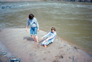 Sandy and her brother playing in the mud on the banks of the Rio Grande River in New Mexico