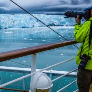 man photographing glacier from ship