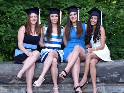(L to R) Eleni Konidaris ’15, Jennifer Gammond ’15, Tracy DiPetrillo ’15, and Cassandra Samji ’15 pose for a photo in their graduation caps.