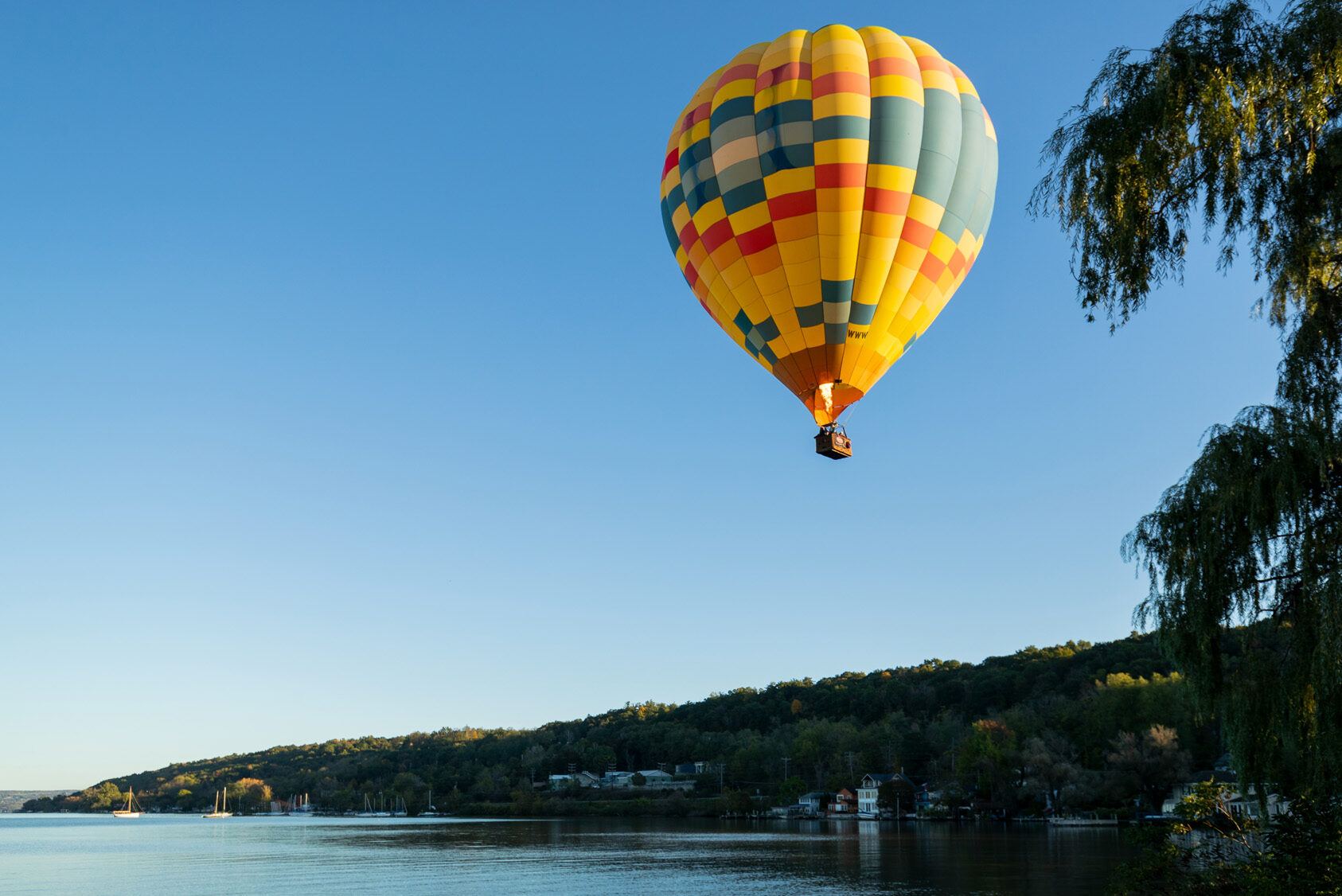 A hot air balloon soars over Cayuga Lake in Upstate New York